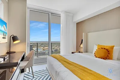 a bedroom with a bed and a desk and a large window at Beach House Design in Hollywood