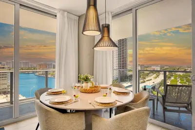 a dining room with a table and chairs and windows at Very Chic - Bay View & Balcony - Amazing Pools- Gym in Hollywood