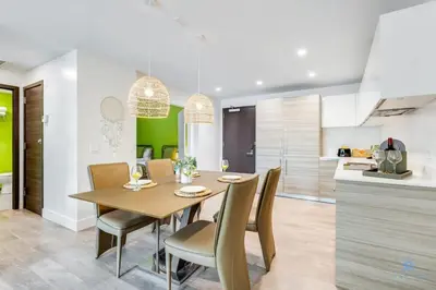 a kitchen and dining room with a wooden table and chairs at Modern Luxury Retreat: Rooftop Pool Ocean Views in Hollywood