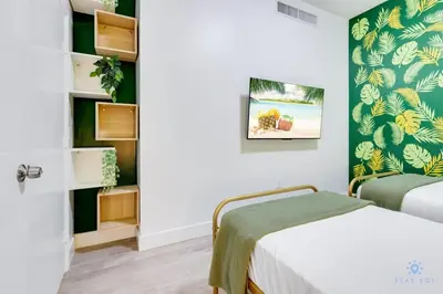 a bedroom with a bed and a green wall at Modern Luxury Retreat: Rooftop Pool Ocean Views in Hollywood