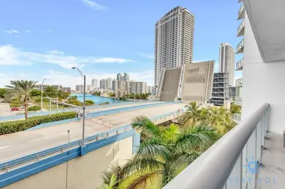 a balcony with palm trees and a view of the city at Modern Condo - Amazing Pool - Gym - Balcony in Hallandale Beach