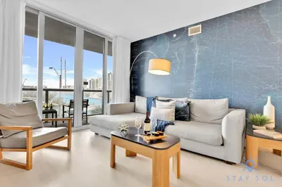 a living room with a couch and a table at Modern Condo - Amazing Pool - Gym - Balcony in Hallandale Beach