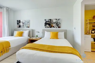 two beds in a room with yellow and white at Modern Condo - Amazing Pool - Gym - Balcony in Hallandale Beach