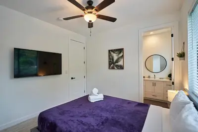a bedroom with a purple bed and a ceiling fan at Modern New Construction Villa in Hollywood