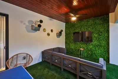 a green wall with a couch and a tv at Modern New Construction Villa in Hollywood