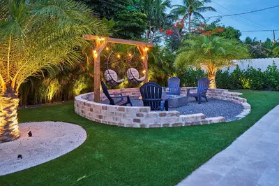 a backyard with chairs and a fire pit with lights at Modern New Construction Villa in Hollywood