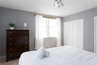 a bedroom with a white bed and a dresser and a window at South Beach One Bedroom Condo with Parking Spot in Miami Beach