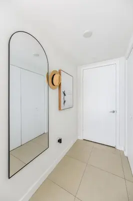 a hallway with a mirror and a door at MonteCarlo Miami Beach in Miami Beach
