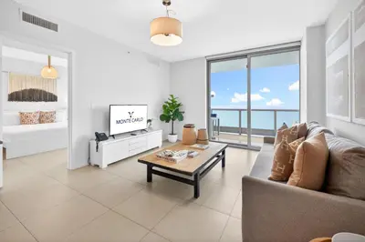 a living room with a couch and a tv at MonteCarlo Miami Beach in Miami Beach