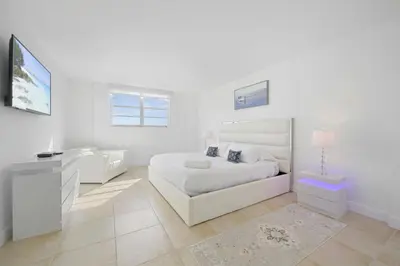 a white bedroom with a white bed and a desk at Spacious apartment in Ocean Reserv of 2br - 2bth great price in Sunny Isles Beach