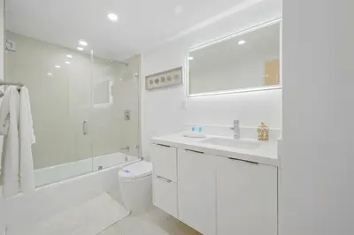 a white bathroom with a toilet and a sink at Spacious apartment in Ocean Reserv of 2br - 2bth great price in Sunny Isles Beach