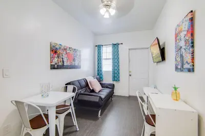 a living room with a couch and a table and chairs at Cozy South Beach 1BR Apt Near Beach & Ocean Drive in Miami Beach