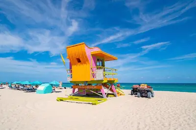 a lifeguard tower on the beach with people on the beach at Cozy South Beach 1BR Apt Near Beach & Ocean Drive in Miami Beach