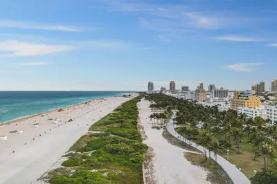 a view of a beach with palm trees and the ocean at Cozy South Beach 1BR Apt Near Beach & Ocean Drive in Miami Beach