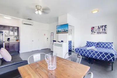 a living room with a table and a bed at Chic Large Studio Apt Near Ocean Drive South Beach in Miami Beach
