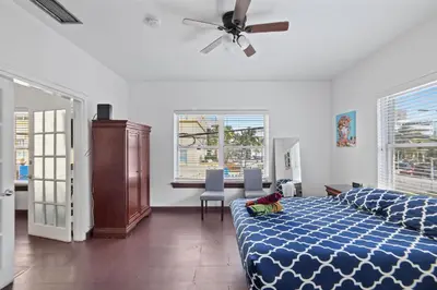 a bedroom with a blue bed and a ceiling fan at South Beach 2BR with Private Balcony, Walk to Beach in Miami Beach