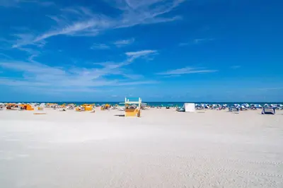 a beach with a bunch of chairs and people on it at Fun & Value Ocean Dr, South Beach, Steps to Beach in Miami Beach