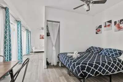 a bedroom with a bed and a table and a ceiling fan at Balcony Chic Apt, w/2 Queenbeds, on Ocean Dr Beach in Miami Beach
