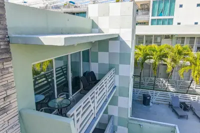 a balcony of a building with chairs and palm trees at Balcony Beach View w/2 Queen beds, Ocean Dr Beach in Miami Beach