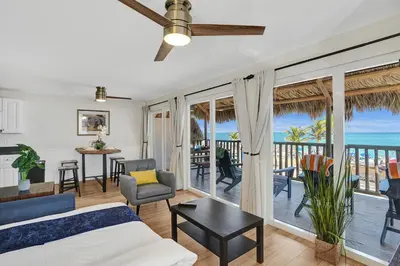 a living room with a bed and a balcony with the ocean at Beach Condo 2BR & Efficiency Combo on Hollywood Beach in Hollywood