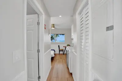 a hallway with white walls and a white door at Beach Condo 2BR & Efficiency Combo on Hollywood Beach in Hollywood