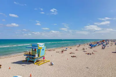 a beach with a bunch of people on it at Beachside 1 b/r, w/2 Queen Beds, Ocean Drive SOBE in Miami Beach
