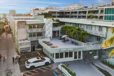 a white car parked in a parking lot in front of a building at Beachside 1 b/r, w/2 Queen Beds, Ocean Drive SOBE in Miami Beach