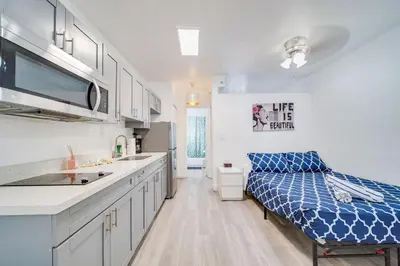 a kitchen with white cabinets and a blue bed in it at Beachside 1 b/r, w/2 Queen Beds, Ocean Drive SOBE in Miami Beach