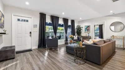 a living room with a couch and a table at Hot Tub Firepit Deck 10mins to Beach Near Las Olas Middle Terrace Cottage by AvantStay in Fort Lauderdale