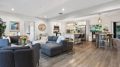 a living room with two couches and a kitchen at Hot Tub Firepit Deck 10mins to Beach Near Las Olas Middle Terrace Cottage by AvantStay in Fort Lauderdale