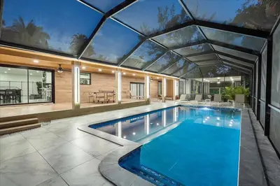 a swimming pool in a house with a glass ceiling at VillaKOBO Heated pool Spa Golf Tennis crocodile in Miami