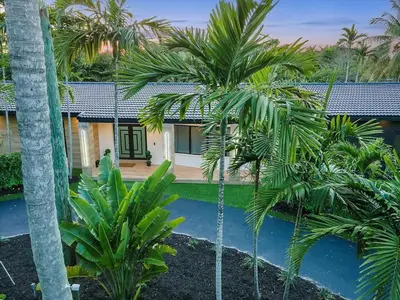 a house with palm trees in front of a swimming pool at VillaKOBO Heated pool Spa Golf Tennis crocodile in Miami