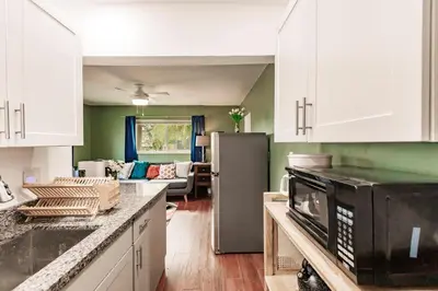 a kitchen with a refrigerator and a living room at Uhost AI - Updated 1B1B Hideaway - Sleeps 3 in Hollywood
