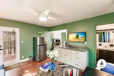 a kitchen with green walls and a vase of flowers on a table at Uhost AI - Updated 1B1B Hideaway - Sleeps 3 in Hollywood
