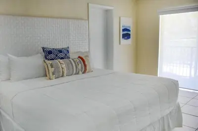 a large white bed in a room with a window at Suites at Coral Resorts in Miami