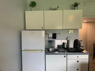 a kitchen with white cabinets and a white refrigerator at Walk to the beach, Studio, with Pool and FREE Parking in Hallandale Beach