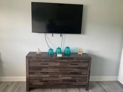 a wooden dresser with a television on top of it at Walk to the beach, Studio, with Pool and FREE Parking in Hallandale Beach