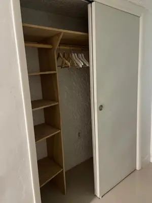 a closet with wooden shelves and shoes in it at CHEERFUL PRIVATE ROOM 2 MILES AWAY FROM SUNNY ISLES BEACH in North Miami Beach
