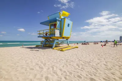 a lifeguard tower on a beach with a crowd of people at Deco Ocean Dr Deal, w/2 Queen Beds, South Beach in Miami Beach