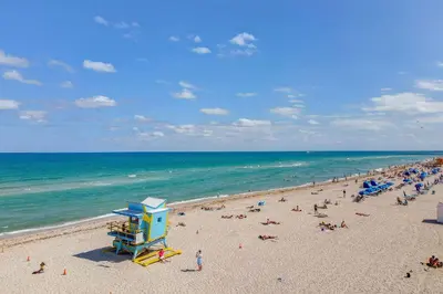 a beach with a crowd of people and the ocean at Deco Ocean Dr Deal, w/2 Queen Beds, South Beach in Miami Beach