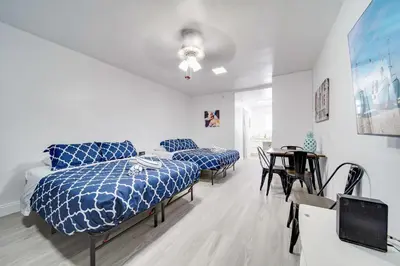 a bedroom with two blue beds and a table at Deco Beachside Apt, w/2 Queen Beds, Washer/Dryer in Miami Beach