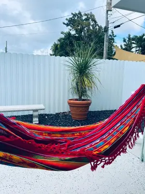 a hammock with a potted plant sitting next to a fence at Casita Cafe in Miami