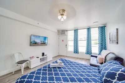 a bedroom with a bed and a couch and a tv at Ocean Drive Beach Fun, w/2 Queen Beds South Beach in Miami Beach