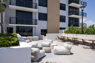 a patio with chairs and tables in front of a building at Wynwood 1br w gym pool wd nr shops bars MIA-34 in Miami