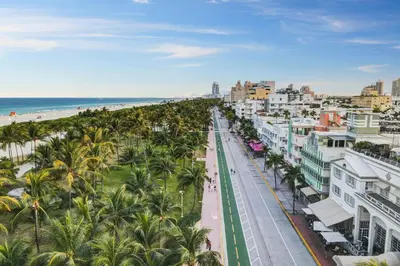 a city street with palm trees and the beach at Balcony Deco Apt, w/2 QueenBeds, on Ocean Dr Beach in Miami Beach