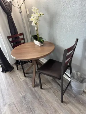 a wooden table with two chairs and a vase with flowers at Miami Sunny Isles Beach Ocean Front Resort Condo with balcony Pool, Beach,Gym,Valet Parking in Sunny Isles Beach