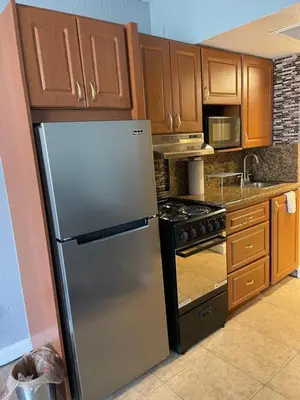 a kitchen with a stainless steel refrigerator and wooden cabinets at Miami Sunny Isles Beach Ocean Front Resort Condo with balcony Pool, Beach,Gym,Valet Parking in Sunny Isles Beach