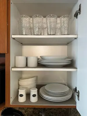 a cupboard filled with plates and bowls and glasses at Miami Sunny Isles Beach Ocean Front Resort Condo with balcony Pool, Beach,Gym,Valet Parking in Sunny Isles Beach
