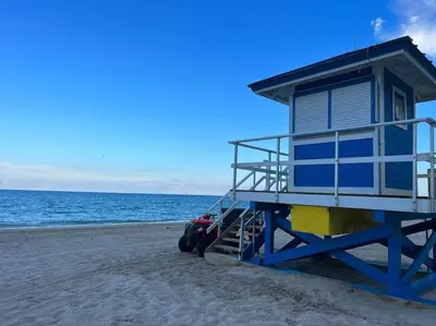 a lifeguard house on the beach with a car parked next to it at Your Beach Escape Starts Here, Studio for Families in Hallandale Beach