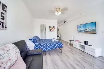 a living room with a bed and a couch at Steps 2 Beach, Ocean Drive Deco Apt w/2 Queen Beds in Miami Beach